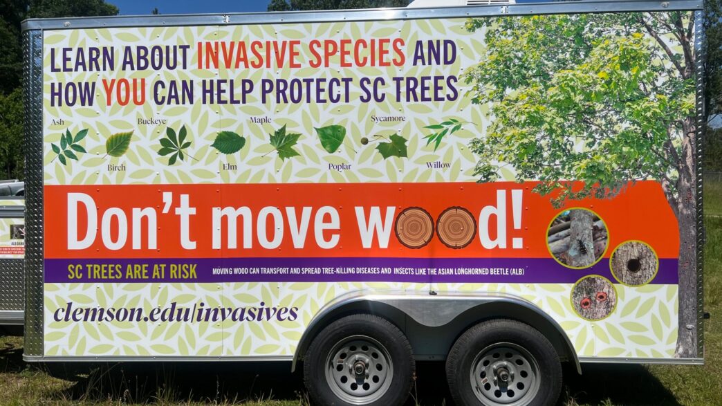 A trailer wrapped with various Clemson-centric messages reminding people to not move wood.