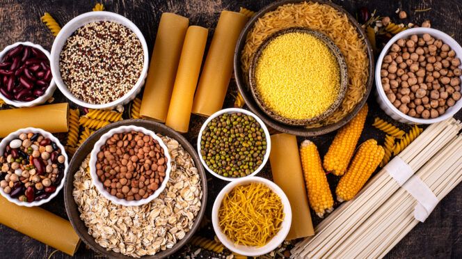 A photo that shows bowls f different sources of carbs in food, including pasta, corn, beans.