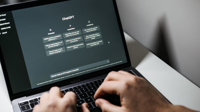 Hands type a prompt on a laptop into a ChatGPT text box.