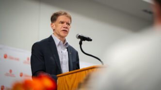 Cole Smith addresses an audience from a podium