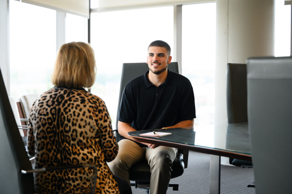 Jackson Wisecarver speaks with Gail DePriest in a conference room.