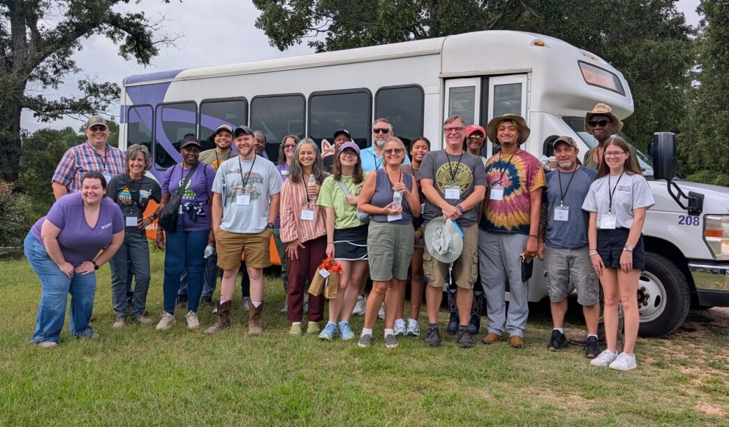 Participants in the organic certification workshop stand inffront of their bus.
