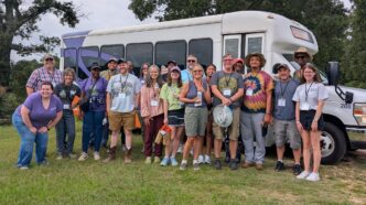 Participants in the organic certification workshop stand inffront of their bus.