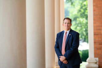 Benjamin Ayers stands next to the Sikes Hall pillars.