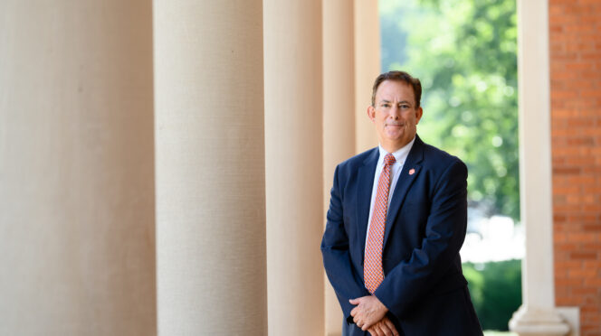 Benjamin Ayers stands next to the Sikes Hall pillars.