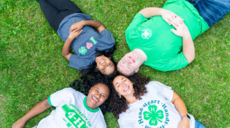 Four youth laying in a circle