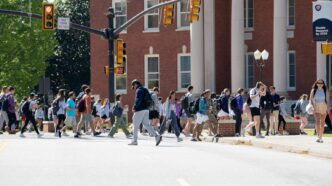 Students walking in front of a brick, columned building