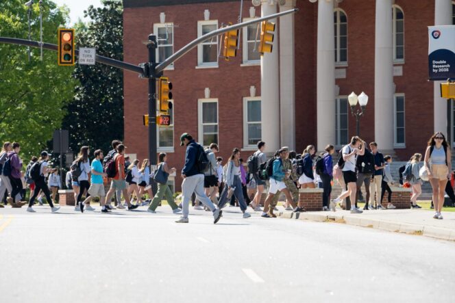 Students walking in front of a brick, columned building