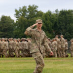 Army RTOC cadet salutes while leading a company behind