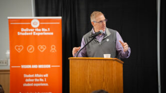 Doug Hallenbeck, vice president for student affairs, speaks from behind a podium