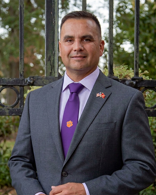 A man in a gray suit with a purple tie