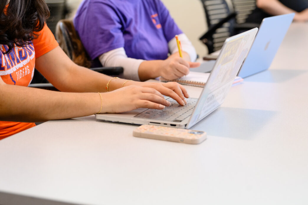 Hands on a laptop keyboard.