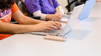 Hands on a laptop keyboard.