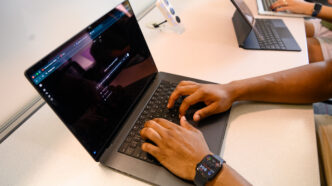 Hands type a prompt into ChatGPT on a laptop.