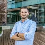 Jake Coplin, a white man with brown hair, MBA student and cyclist, stands in front of Greenville ONE.