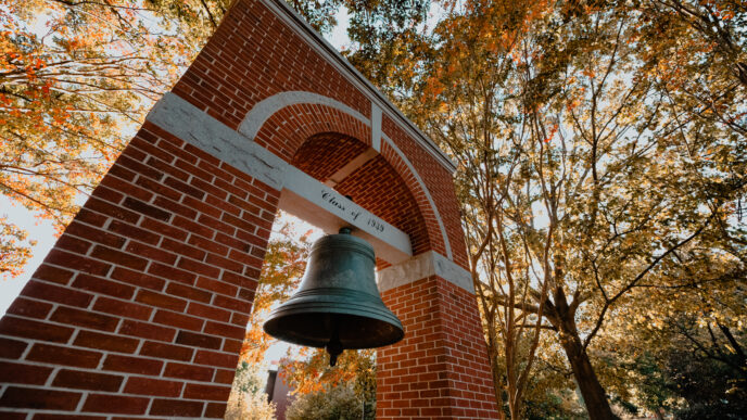 Left, bottom angle shot of the Class of 1939 Bell Tower at the Carillon Garden with fall foliage.