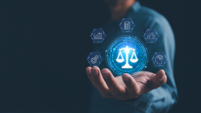 A hand holds a computerized image of the scales of justice