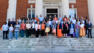 New faculty stand on the steps of Sikes Hall.