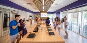 Customers browse laptops and chat with store employees inside the Tiger Tech Shop.