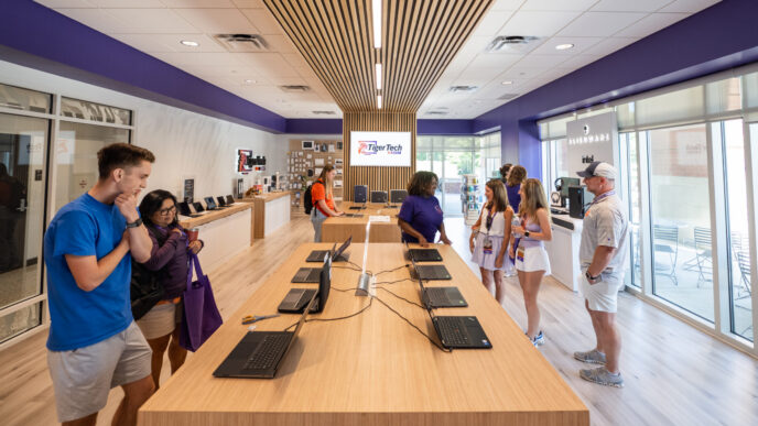 Customers browse laptops and chat with store employees inside the Tiger Tech Shop.