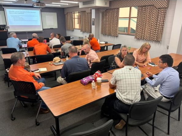 Academic leaders work at tables at the Academic Leader Learning Series.