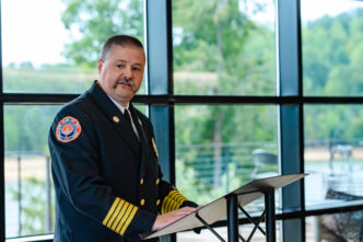 CUFD Chief William Moreland stands at a podium and delivers remarks during a ceremony.