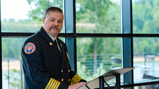 CUFD Chief William Moreland stands at a podium and delivers remarks during a ceremony.