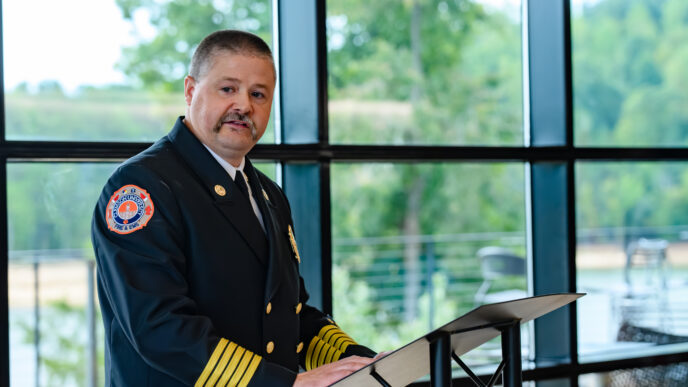 CUFD Chief William Moreland stands at a podium and delivers remarks during a ceremony.