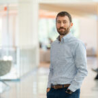 Matthew S. Lewis stands in hallway of Wilbur O. and Ann Powers College of Business