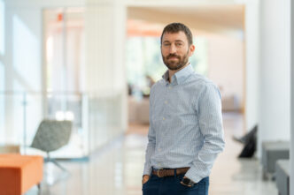 Matthew S. Lewis stands in hallway of Wilbur O. and Ann Powers College of Business