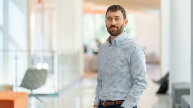Matthew S. Lewis stands in hallway of Wilbur O. and Ann Powers College of Business