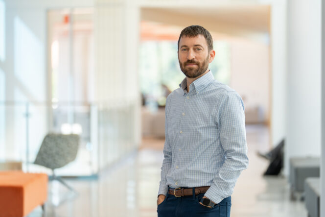 Matthew S. Lewis stands in hallway of Wilbur O. and Ann Powers College of Business