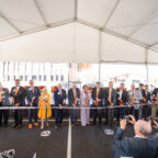 a group of people with scissors, cutting a ribbon