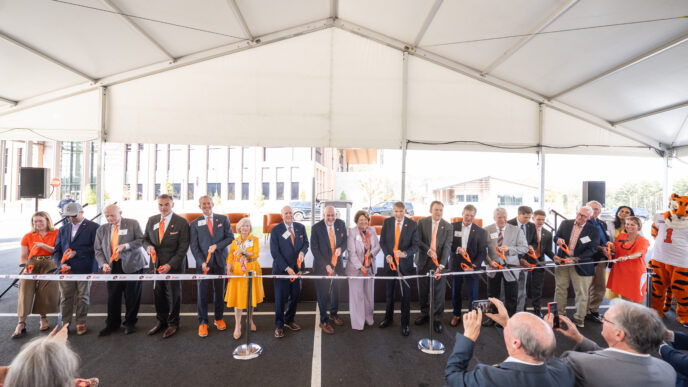 a group of people with scissors, cutting a ribbon