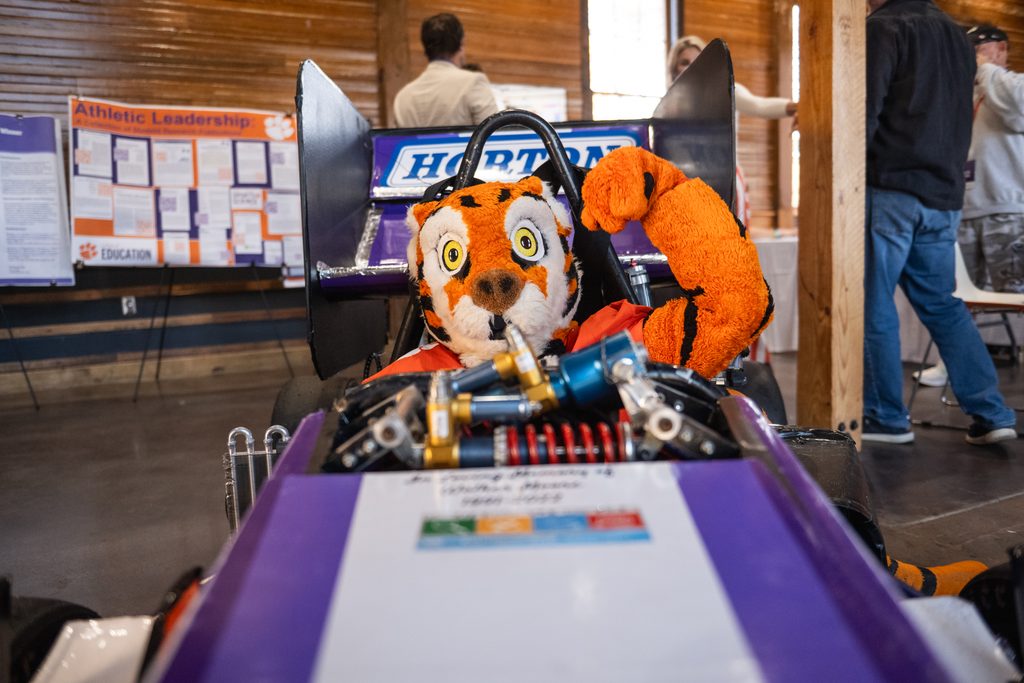 The Tiger mascot sitting in a Formula One car, pumping his fist