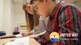 CC Bates reads with a student and a United Way logo is overlaid.